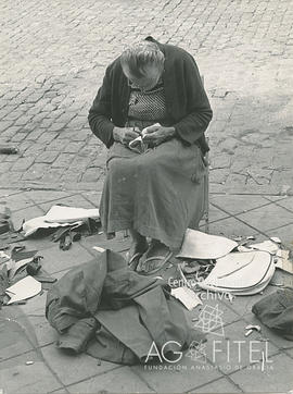 Anciana cosiendo en la calle